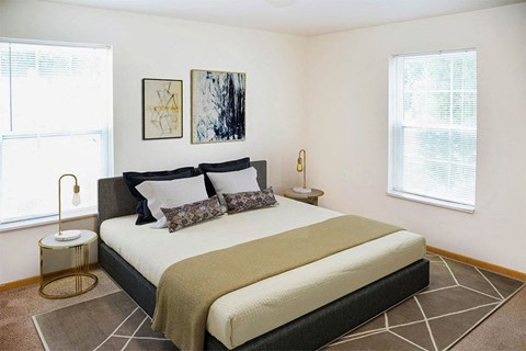 a bedroom with a bed and two windows