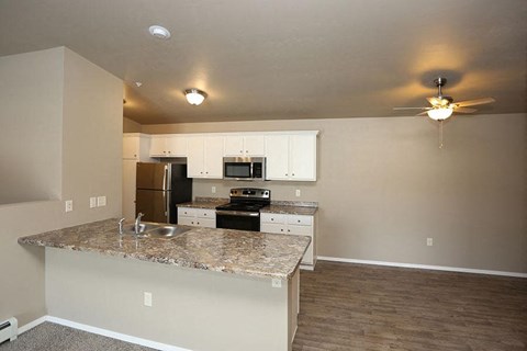 an empty kitchen with a granite counter top
