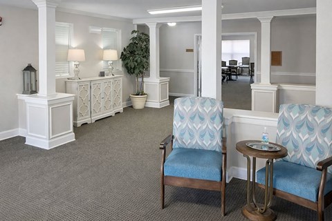 A waiting room with two chairs and a table.
