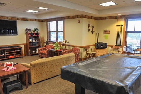 A room with a pool table and a couch.