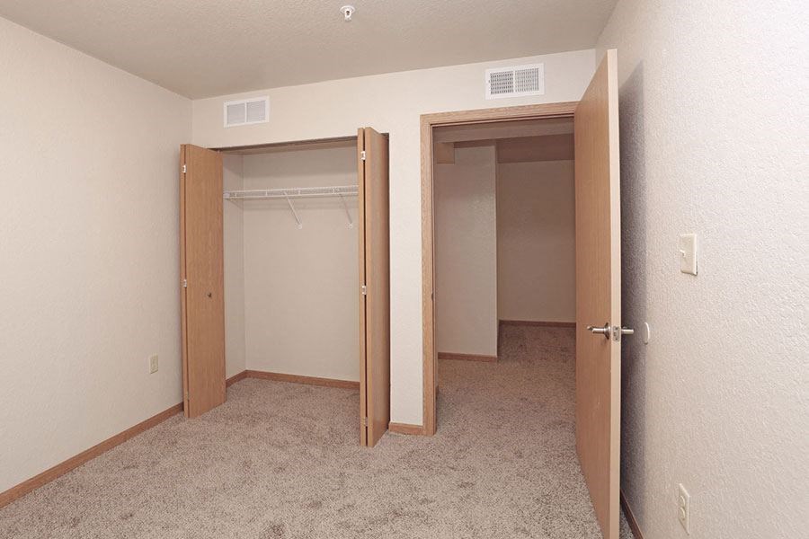 an empty room with a closet and two doors