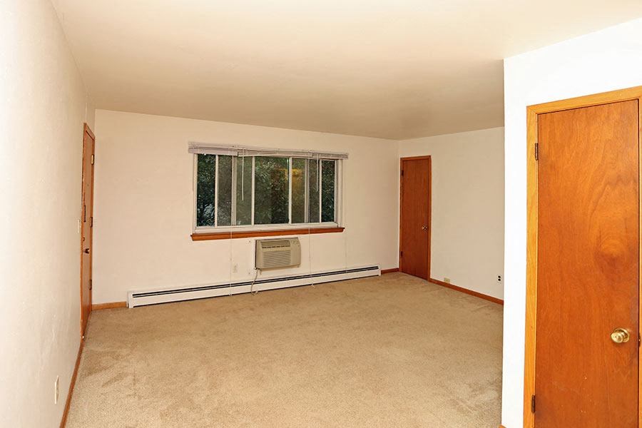 an empty room with a window and a door