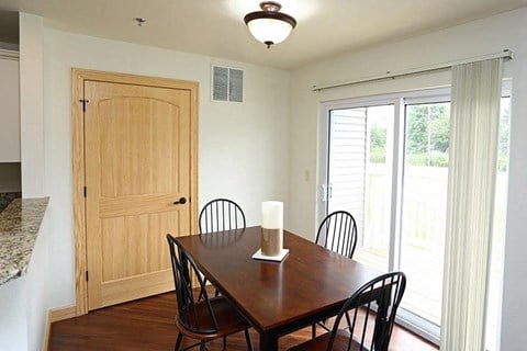 a dining room with a wooden table and chairs