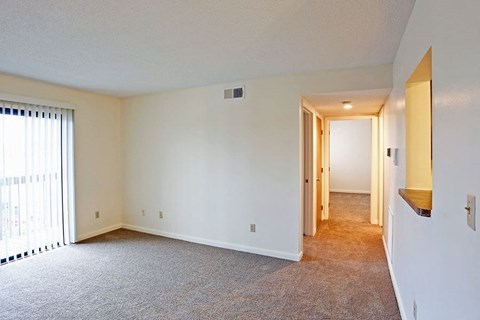 an empty living room with a door to a hallway