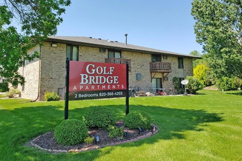 a golf bridge apartments sign in front of a building