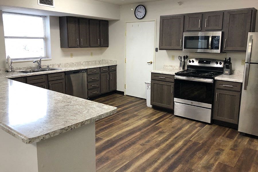 a kitchen with stainless steel appliances and wooden floors