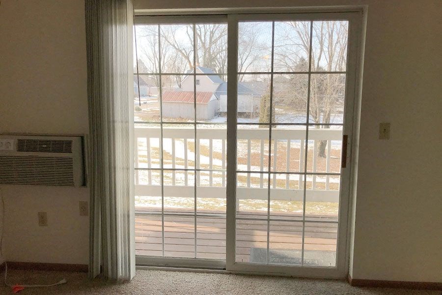 a living room with a large window with blinds