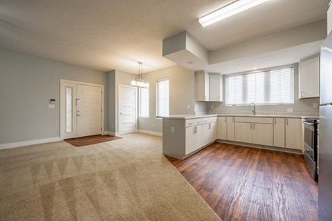 A kitchen with white cabinets and a refrigerator.