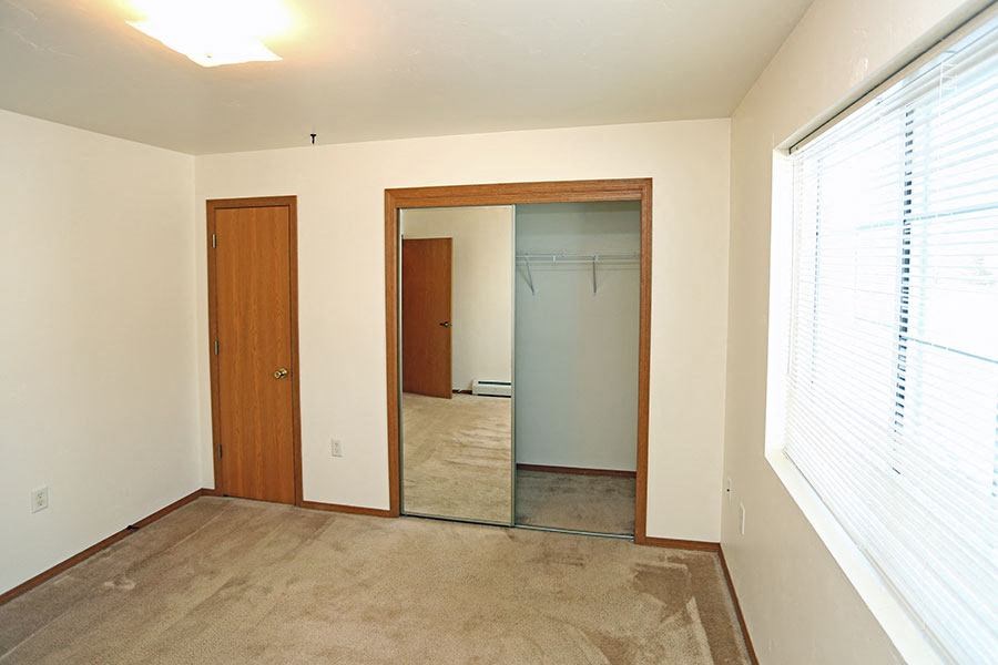 an empty room with a large window and a door