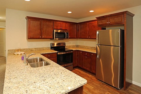 a kitchen with stainless steel appliances and granite counter tops