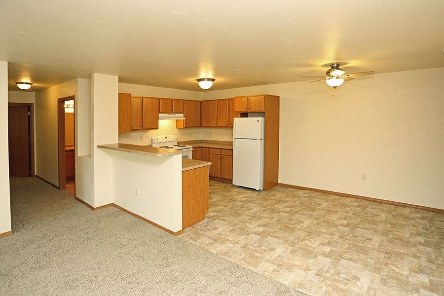 an empty kitchen with a refrigerator and a sink