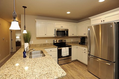 A kitchen with granite countertops and stainless steel appliances.