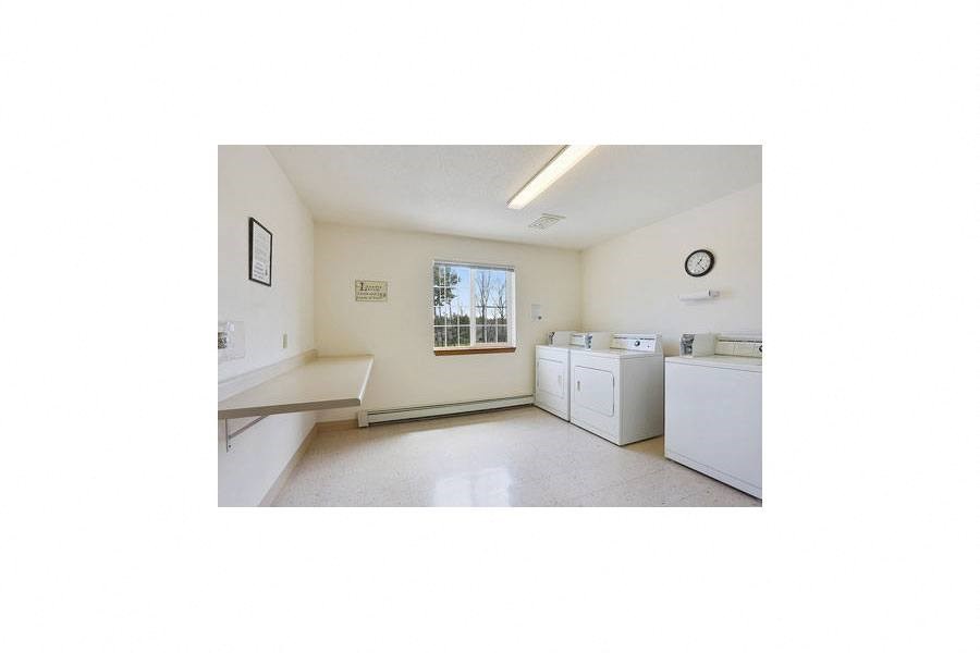a white kitchen with a sink and a washing machine