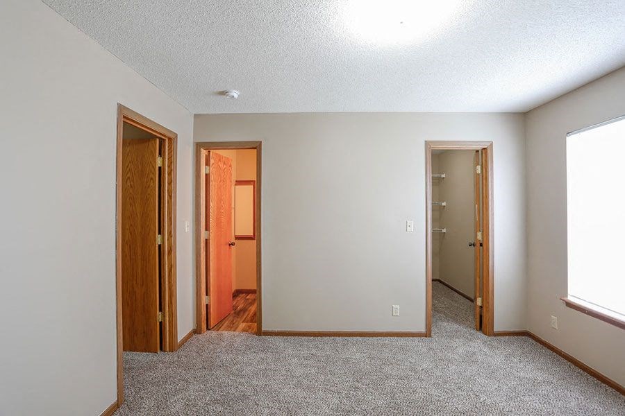 a empty room with two doors and a window