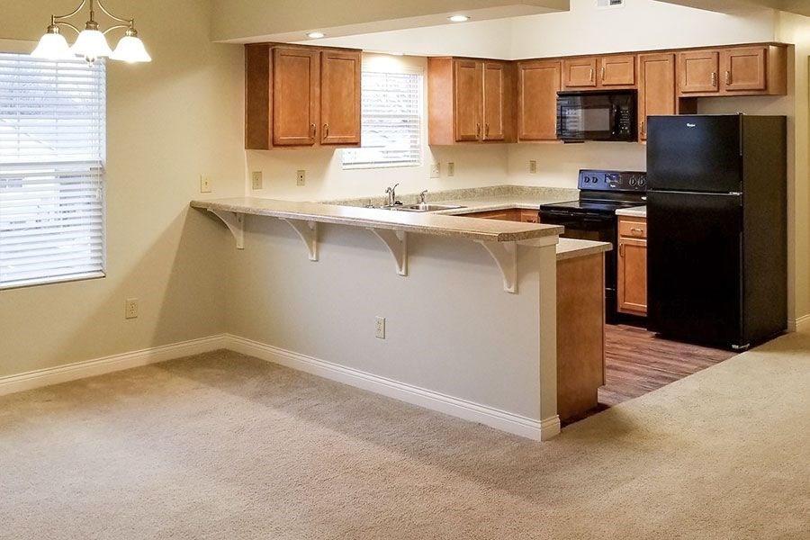 A kitchen with wooden cabinets and black appliances.