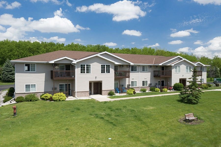 a large white house with a green lawn and trees