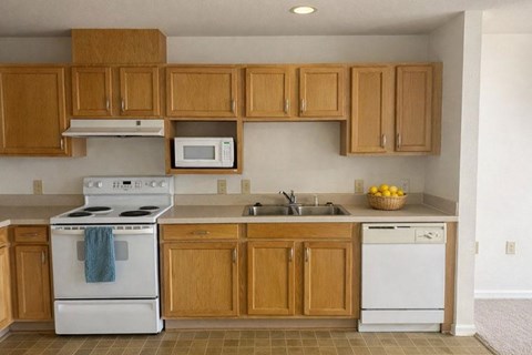 A kitchen with wooden cabinets and a white stove.