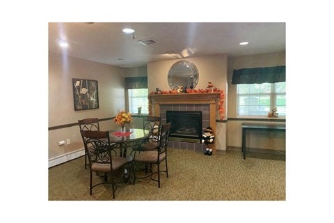 A living room with a fireplace and a dining table.