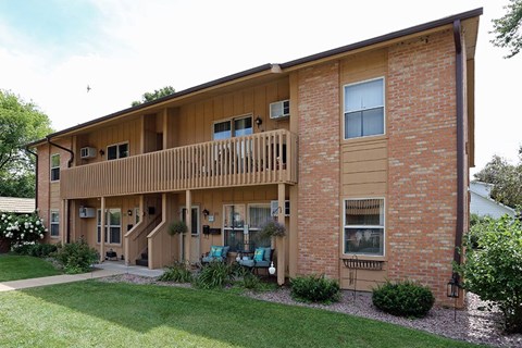 A two-story brick building with a balcony on the second floor.