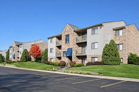 Apartment building with a parking lot in front.