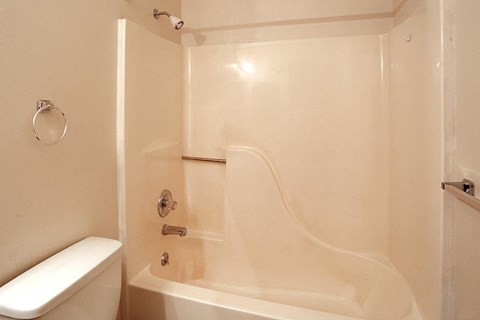 a white bathroom with a toilet and a bath tub