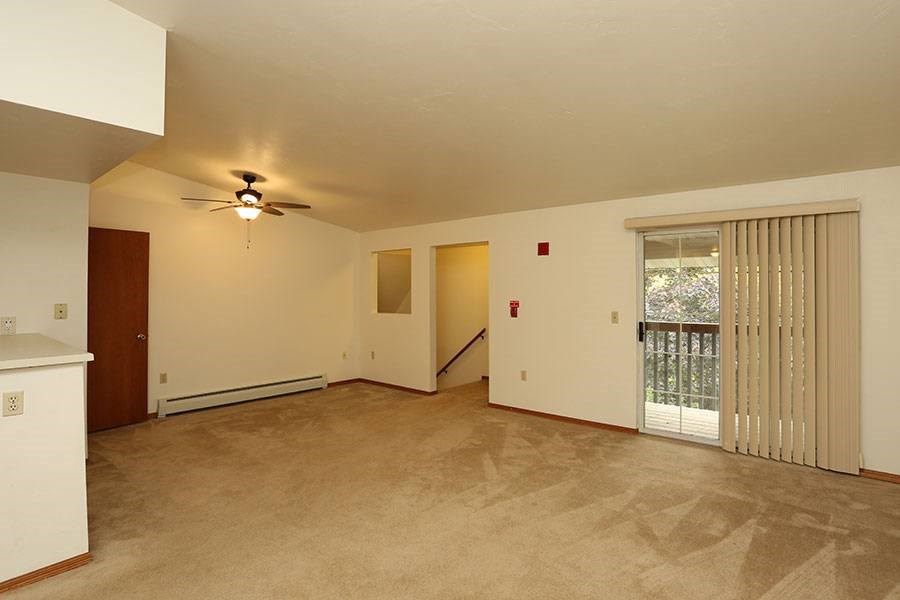 A room with a ceiling fan and a window with blinds.