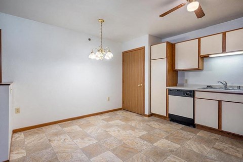 A kitchen with a tile floor and a ceiling fan.