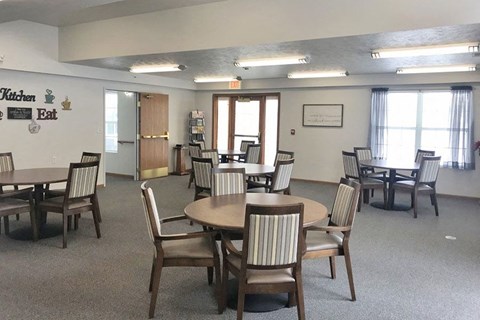 A room with a dining table and chairs.