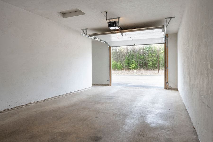 A large empty room with a doorway leading outside.