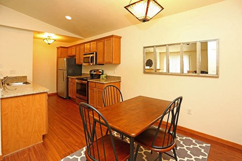 a kitchen with a wooden table and chairs