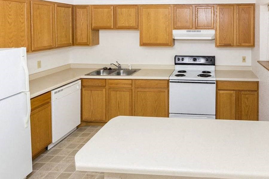 a kitchen with white appliances and wooden cabinets