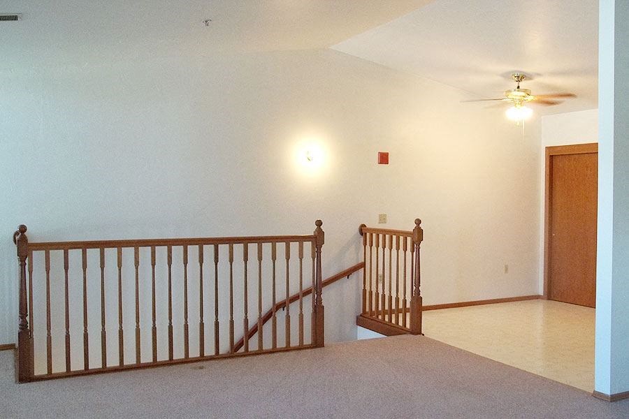 a living room with a staircase and a ceiling fan