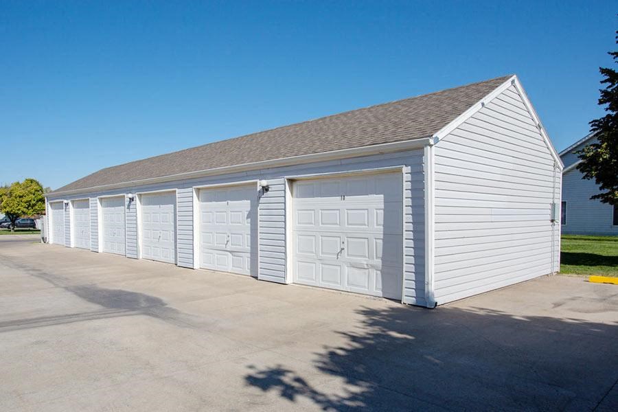 a small white garage with white doors and a roof