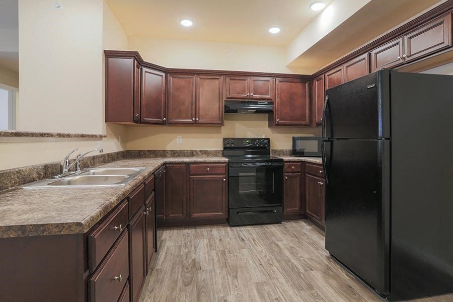 a kitchen with black appliances and wooden cabinets