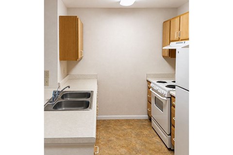 A kitchen with a white oven and a stainless steel sink.