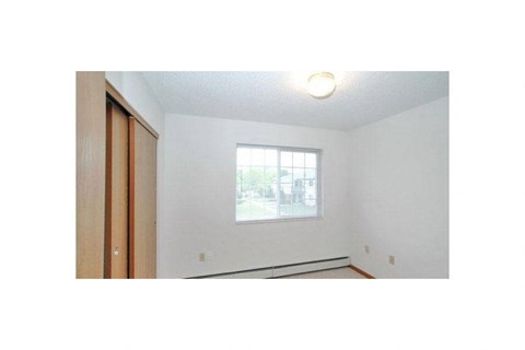 an empty room with a window and a wooden door