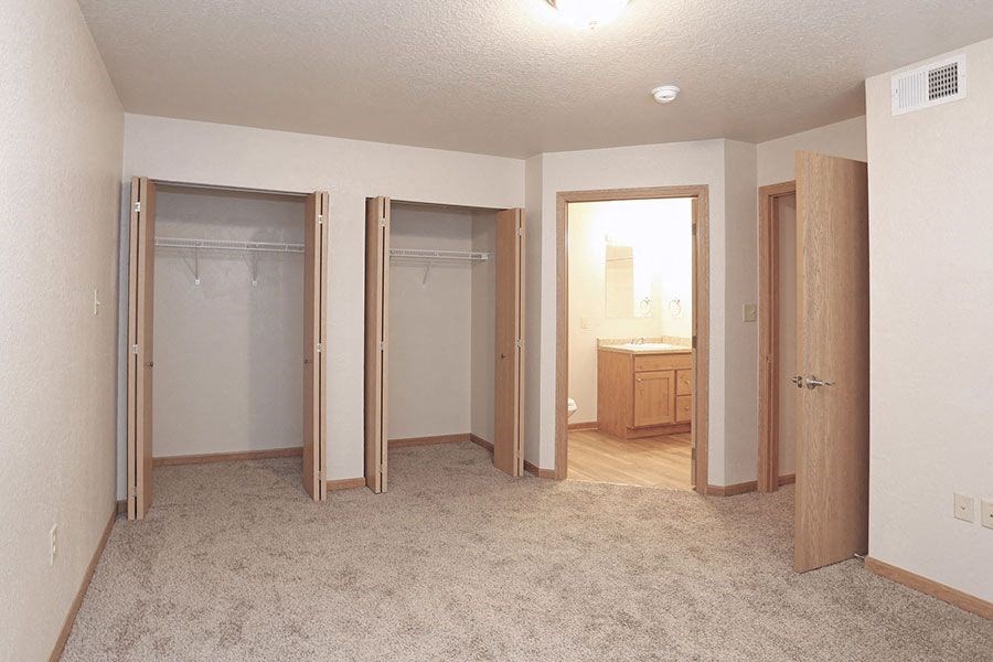 an empty bedroom with three closets and a bathroom