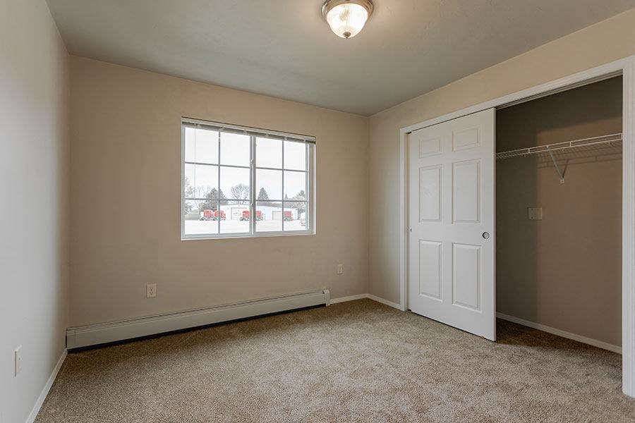 an empty room with a white door and a window