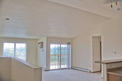 an empty living room with a door to a balcony