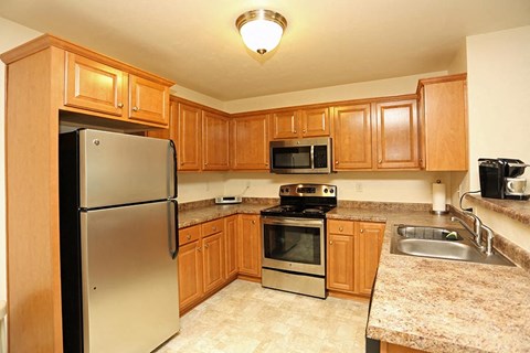 a kitchen with stainless steel appliances and wooden cabinets