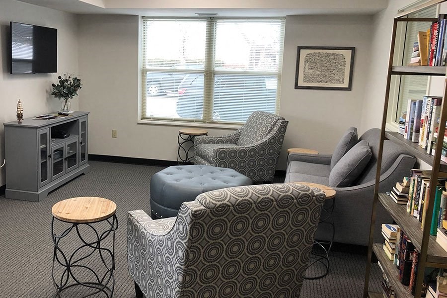 a living room with a couch and chairs and a tv