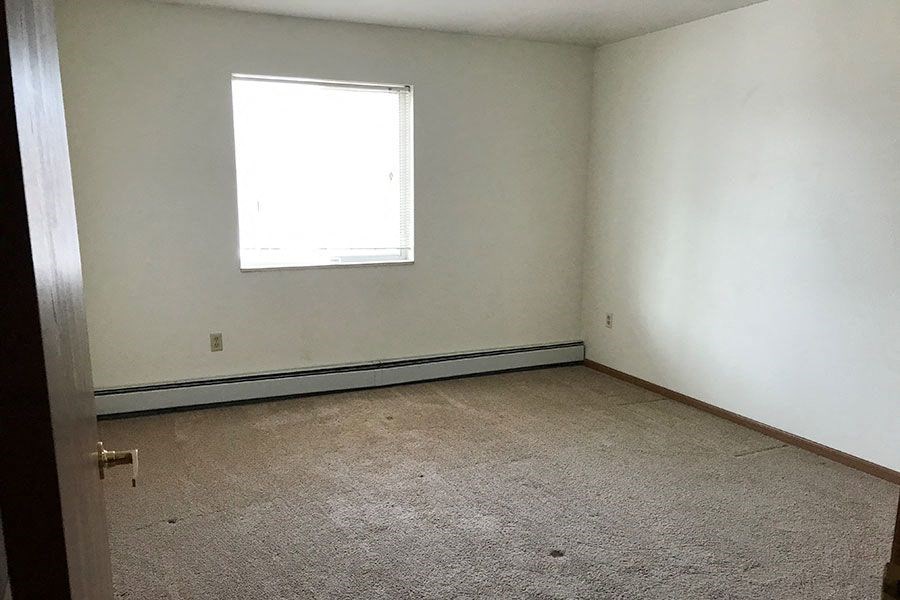 an empty room with a window and a carpet
