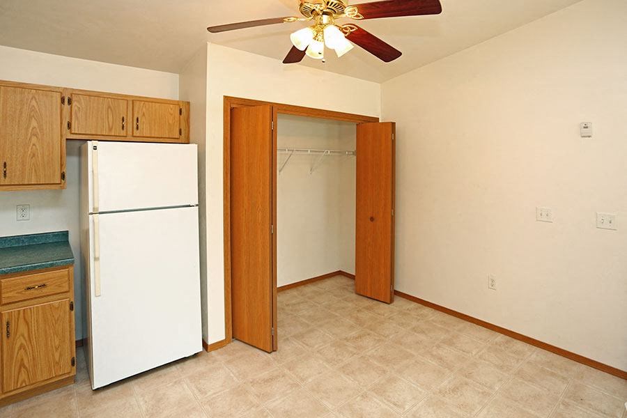 a kitchen with a white refrigerator and a ceiling fan