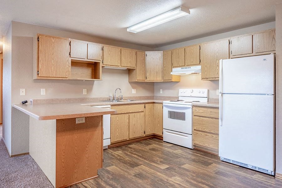 a kitchen with white appliances and wooden cabinets
