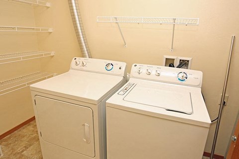 two washers and dryers in a room with a closet