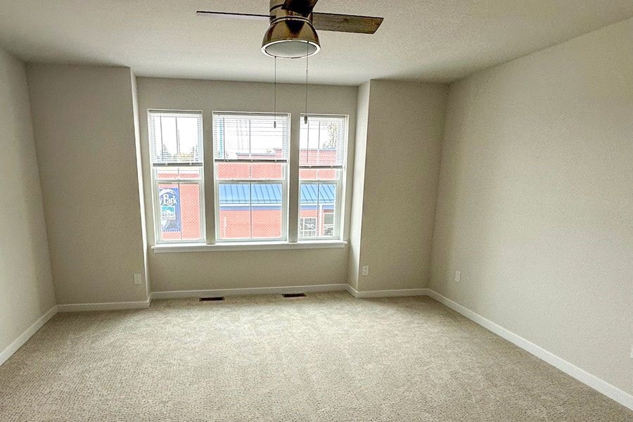 Empty room with a ceiling fan and a window.