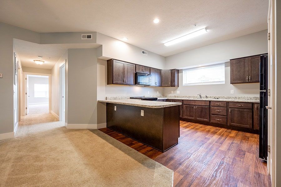 A kitchen with dark wood cabinets and a white countertop.