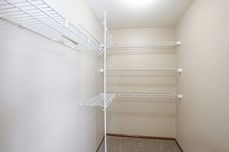 a white closet with two white shelves in it