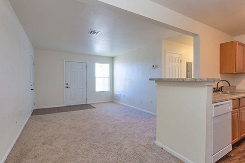 A kitchen area with a white dishwasher and wooden cabinets.