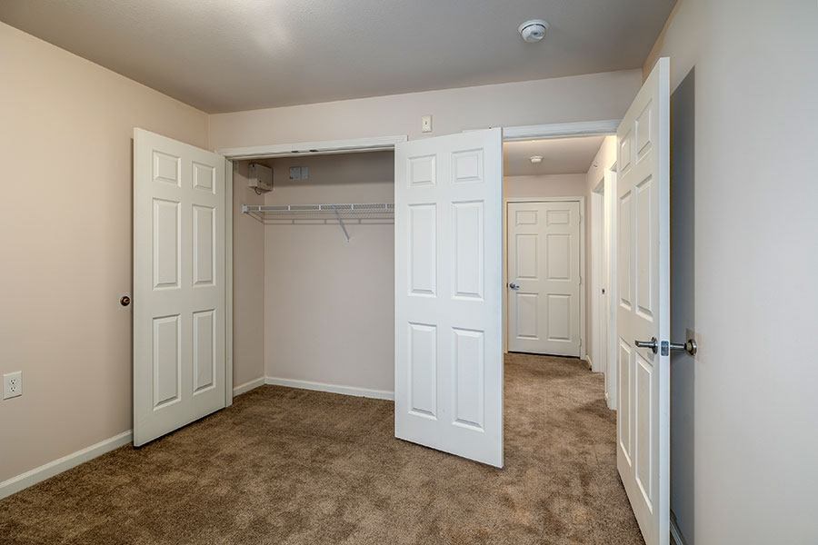 A room with a carpeted floor and white doors.